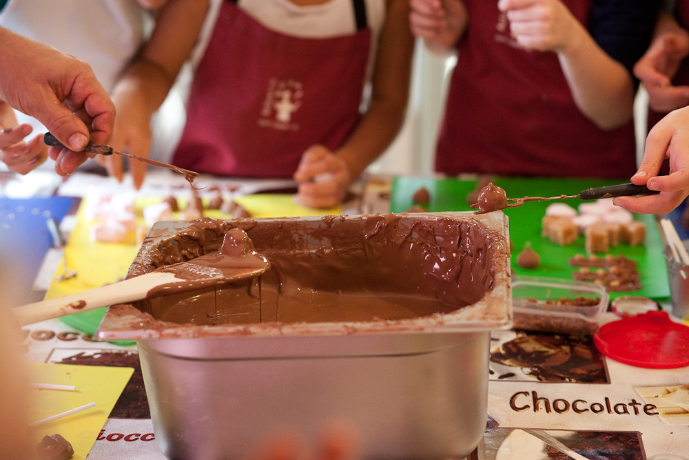 Dipping chocolates into a tank of chocolate