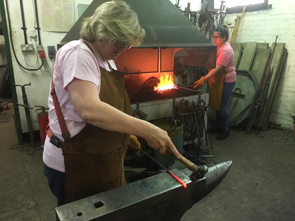 People at the forge.  Once hammering on an anvil and one in the fire on a team day experience