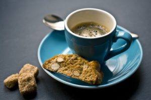 espresso coffee in blue cup with biscuit and sugar cubes