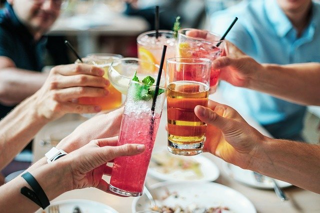 People touching glasses of various drinks in a cheers motion