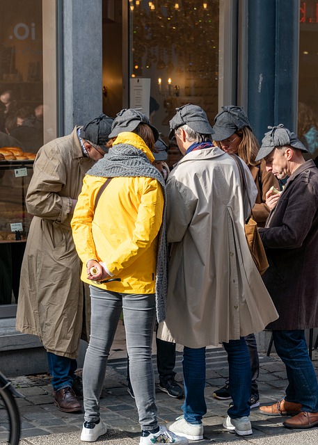 A group of people in a huddle on the street each wearing a deerstalker hat