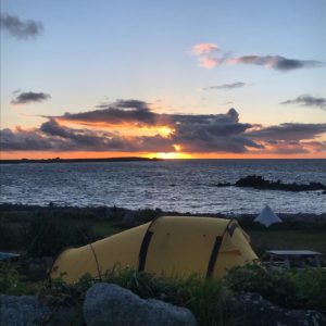 Sunset over sea, with tent in the foreground