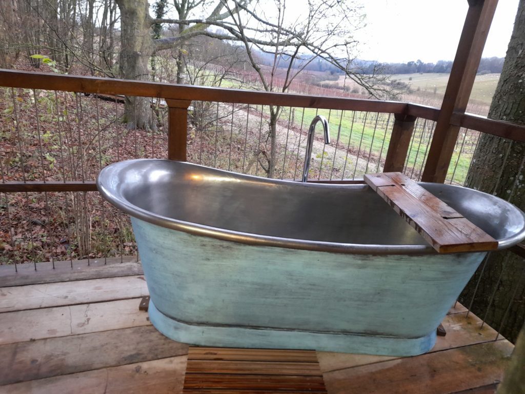 Bathtub on balcony.  Treehouse in the woods