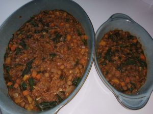 Lentil and spinach bake in large and small greeen ceramic oval dishes