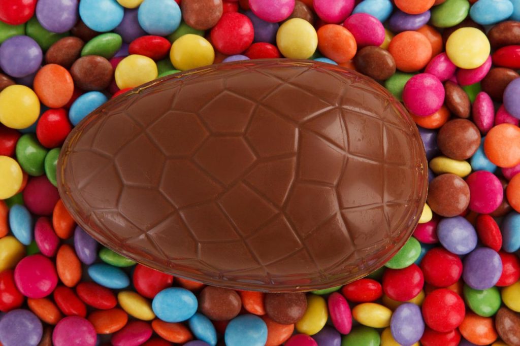 Chocolate Easter egg sitting on a bed of smarties
