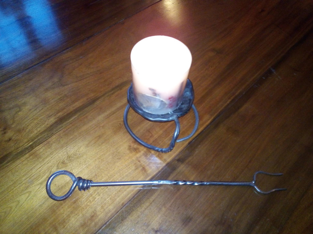 Candle holder and toasting fork on the table (made by a budding blacksmith)
