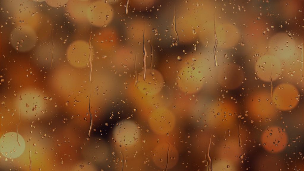 A rainy window with blurred lights behind